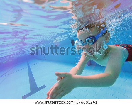 Underwater Young Boy Fun in the Swimming Pool with Goggles. Summer Vacation Fun.