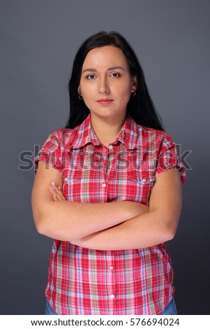 Woman with crossed hands on gray background