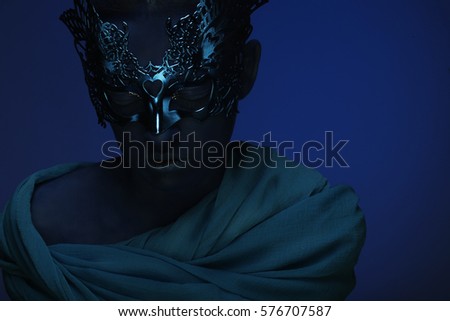 art photo of a beautiful woman with blue face with mask