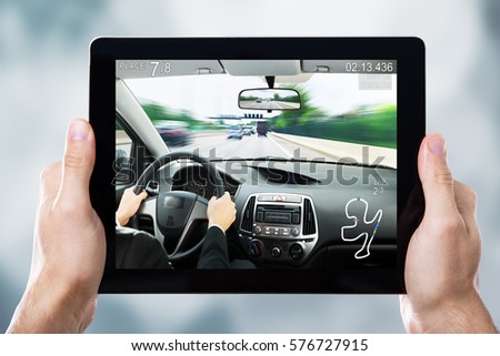 Close-up Of A Person Playing Car Racing Game On Digital Tablet
