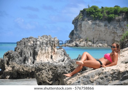 Woman lying on the rocks enjoying sunshine in tropical exotic Dominican Republic