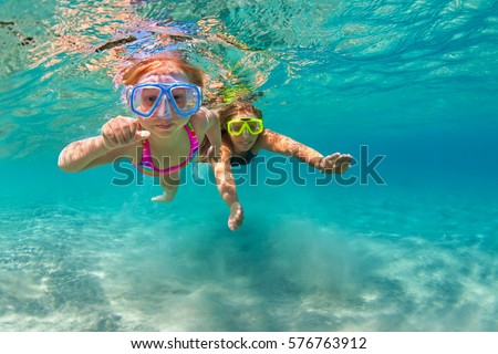 Happy family - mother with baby girl dive underwater with fun in sea pool. Healthy lifestyle, active parent, people water sport outdoor adventure, swimming lessons on beach summer holidays with child.