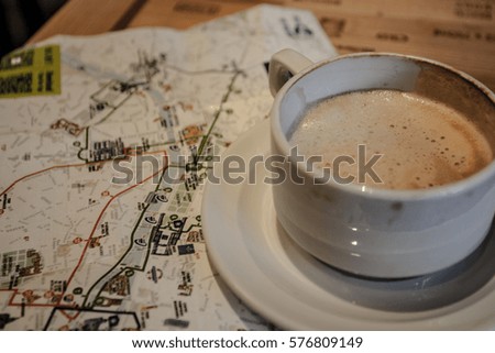 Cup of Cappuccino Coffee and map of paris, travel concept