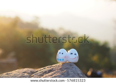 Ceramic doll cute couple on rock with sunshine morning