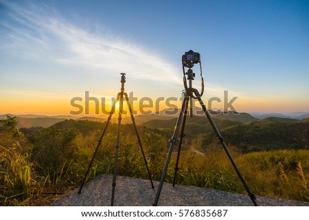 A photographer or traveller using a professional DSLR camera on a tripod