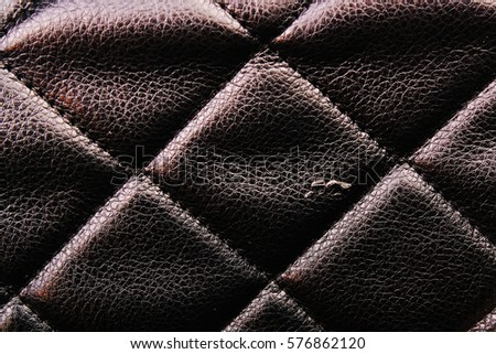Bag material leather faux leather texture. Quilted pattern as background. Black quilted wallpaper.