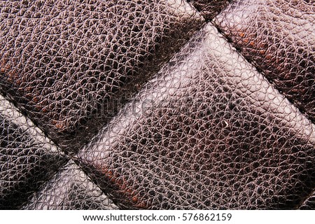 Bag material leather faux leather texture. Quilted pattern as background. Black quilted wallpaper.
