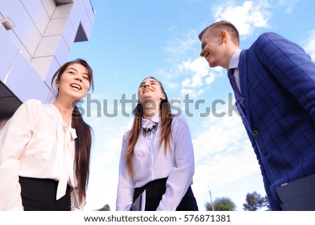 Two cute successful woman and elegant handsome male man successful young office workers, businessmen, students communicate, make deal, shake hands, talk on various topics, lead discussions, discuss