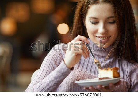 Beautiful woman eating chocolate cake at cafe