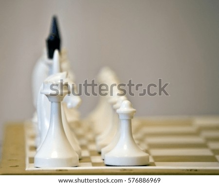 Chess game: white figures in row on wooden board 