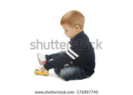 Cute little boy child kid preschooler playing with car toy. Isolated on white background
