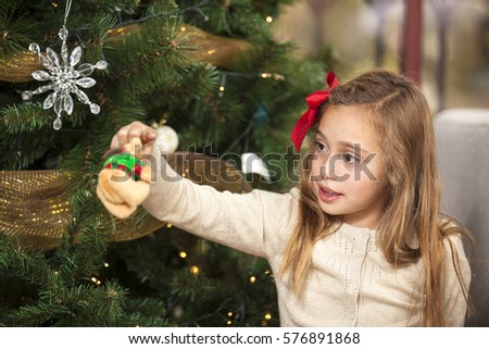 Blond girl decorating the Christmas tree