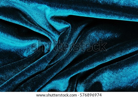 Velvet dress material cloth texture pattern. 
tailoring stitching concept. Shiny beautiful fashion fabric. Shiny clothing material sample.Creased fabric. Blue green,