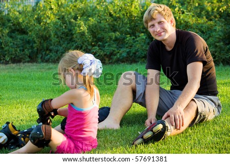 Father and daughter putting on roller skates