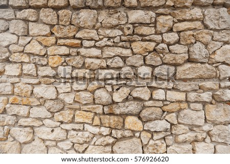 Texture of Medieval old light colored stone wall