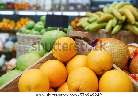 Orange fruits,pamelo and bananas selling at food market in supermarket store.Close up,focus on oranges.Sweet natural tasty product.Natural food store