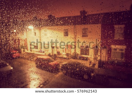 blured street  view through a window covered in rain for background