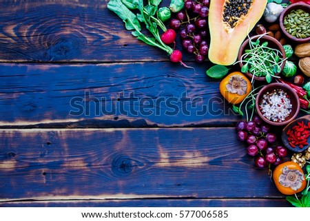 Tasty organic vegetables and fruits, seeds, nuts, spices, superfoods, herbs, condiment for vegan, allergy-friendly, clean eating and raw diet. Old wooden texture background and top view