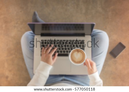 Woman sitting on floor with laptop, stock photo