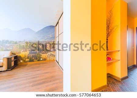 Part of the interior of the living room with a wardrobe and kitchen in orange tones