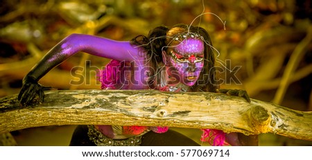 Young caucasian girl with body paint and fantasy make up in mangrove forest outdoors