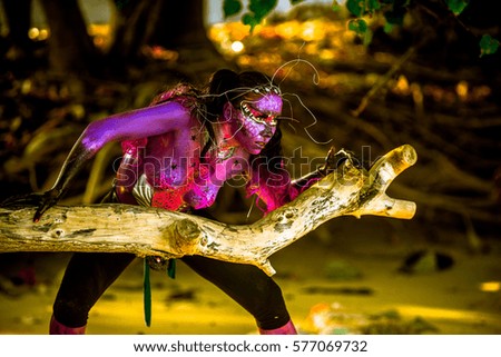 Young caucasian girl with body paint and fantasy make up in mangrove forest outdoors
