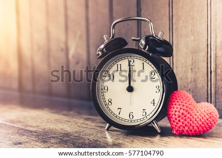Love clock vintage tone timed 12 o'clock, Time of sweet loving past memories story on the old wood background. Royalty-Free Stock Photo #577104790