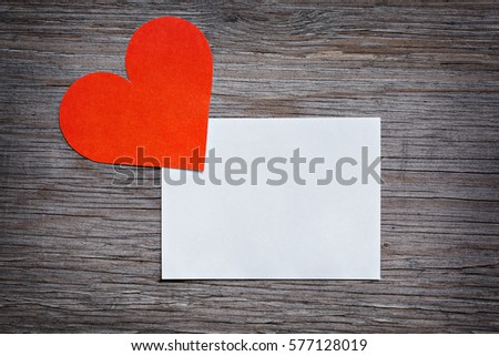 Red paper heart Valentine's card with a clean white sheet of paper. Space for text. Wooden background texture