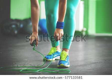 Young fit woman is taking jumping rope. Royalty-Free Stock Photo #577133581