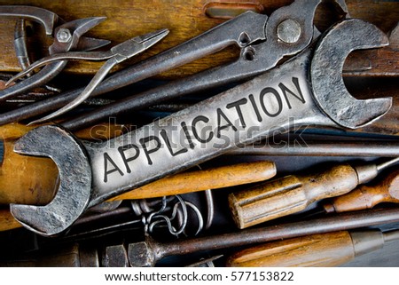 Photo of various tools and instruments with APPLICATION letters imprinted on a clear wrench surface