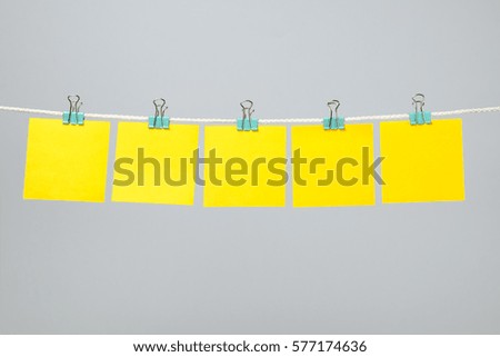 Empty yellow paper notes on the string over color background