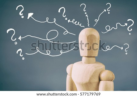 image of wooden dummy with may question marks. Confusion and doubt concept