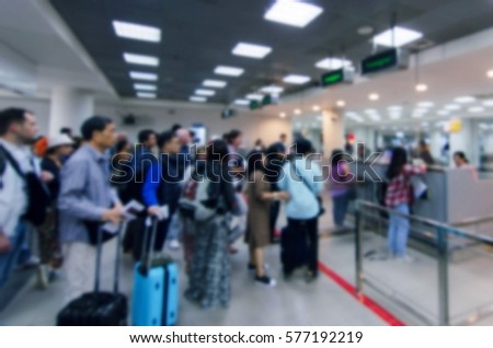 Blurred defocused image of travellers queue at immigration control at airport, for background, color tone effect.