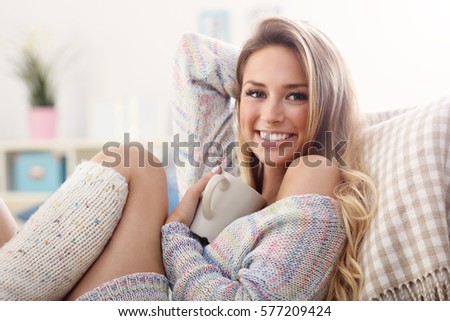 Picture showing adult woman sitting on sofa with coffee
