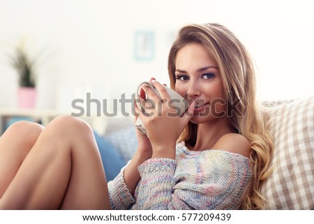 Picture showing adult woman sitting on sofa with coffee
