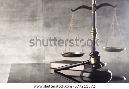 Law concept. Mallet of the judge, books, scales of justice. Gray stone background, reflections on the floor, place for typography. Courtroom theme. Royalty-Free Stock Photo #577211392
