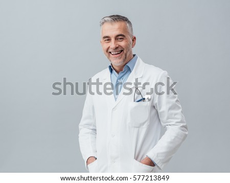 Cheerful mature doctor posing and smiling at camera, healthcare and medicine Royalty-Free Stock Photo #577213849