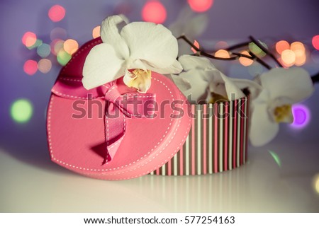 gift box in form of heart on the background of the white orchid 