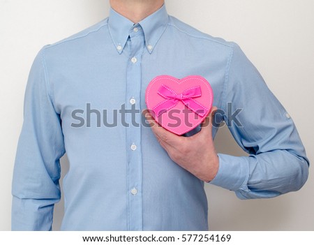   man holding a gift box in the form of heart