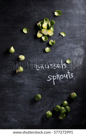 Top view picture of a lot of brussels sprouts over dark background.