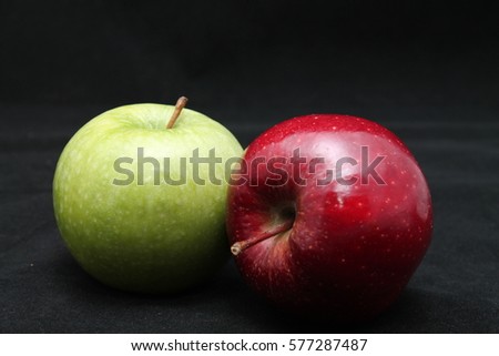 close up of fresh green and red apples on a dark black background isolated