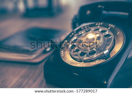 Old black phone on the table with dust and scratches, retro style concept 