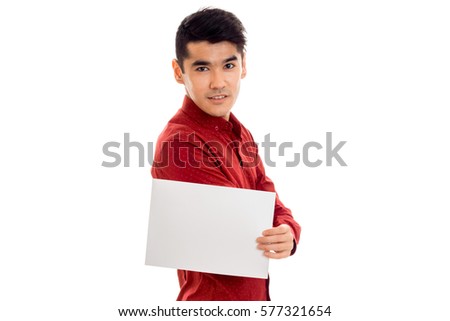 handsome young guy in red t-shirt with empty placard looking at the camera isolated on white background