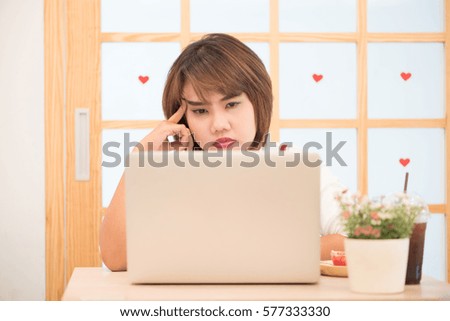 Thai girl thinking about a problem against a heart with window background. Concept of work.