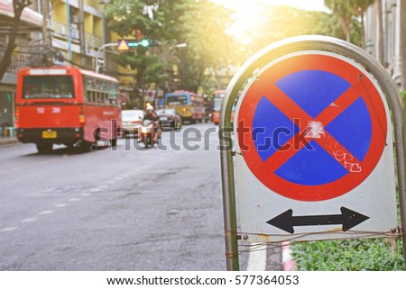 No parking traffic sign on blurred car background. No parking here road sign, Graffiti on no parking, blurry background
