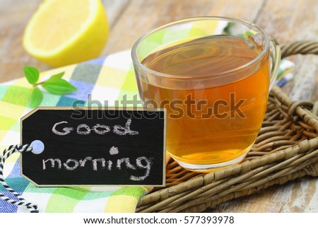 Good morning card with cup of lemon tea on wicker surface
