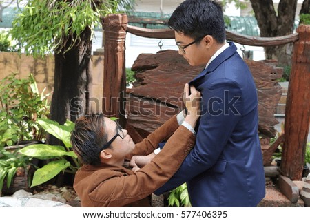 Two businessman are fighting at the public park. Business conflict concept.
