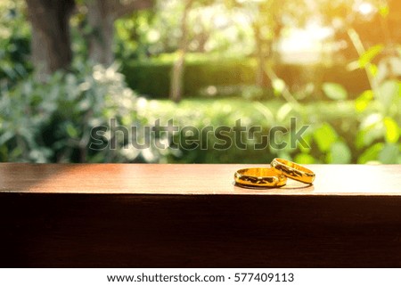 Two gold wedding rings on window in a sunbeam