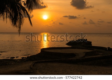 Beautiful sunset on Chang Island with coconut leaves as foreground