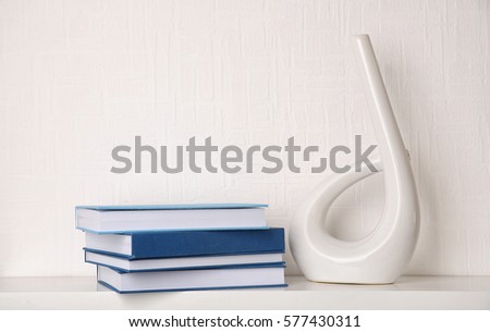 Stack of books on white wooden shelf